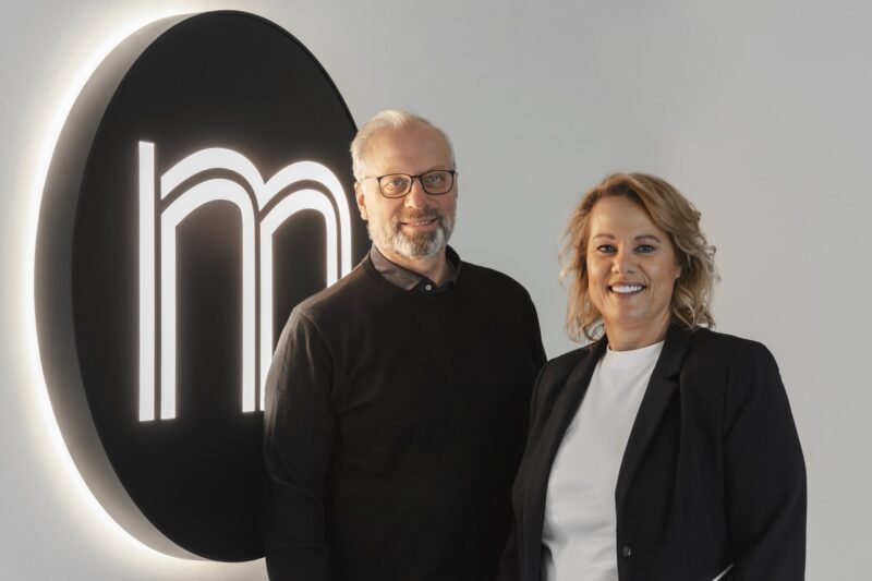 Monika en Klaus naast het logo van familiebedrijf Multiline